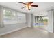 Neutral bedroom with ceiling fan and access to enclosed patio at 12407 Gunstock Ln, Hudson, FL 34667