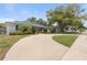 Long driveway leading to a well-maintained home with mature trees and landscaping at 12407 Gunstock Ln, Hudson, FL 34667