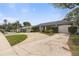 Exterior view showing the driveway and landscaping at 12407 Gunstock Ln, Hudson, FL 34667