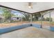Screened porch with a ceiling fan and view of the backyard at 12407 Gunstock Ln, Hudson, FL 34667