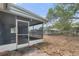 Exterior view of the screened porch with tiled flooring and access to the backyard at 12407 Gunstock Ln, Hudson, FL 34667