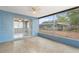 Enclosed porch with tiled flooring, ceiling fan, and outdoor view through large screened windows at 12407 Gunstock Ln, Hudson, FL 34667