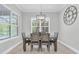 Dining room with a wood table and chairs lit by a modern chandelier and views of the pool outside at 12539 Wetmore Ct, Odessa, FL 33556