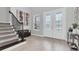 Bright foyer with staircase, decorative front door, light wood floors, and stylish decor at 12539 Wetmore Ct, Odessa, FL 33556