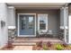 Inviting front porch with double doors, seating, and decorative plants enhance the home's curb appeal at 12539 Wetmore Ct, Odessa, FL 33556