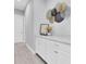 Bright hallway featuring decorative wall art, white cabinets, and neutral paint at 12539 Wetmore Ct, Odessa, FL 33556
