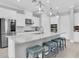 Bright kitchen features white cabinets, a stainless steel refrigerator and an island with stone countertops at 12539 Wetmore Ct, Odessa, FL 33556