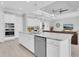 A kitchen features an island with a sink and stainless steel appliances and is open to the living room at 12539 Wetmore Ct, Odessa, FL 33556