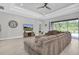 Living room with backyard views, large sectional, entertainment center, tray ceiling, and light wood flooring at 12539 Wetmore Ct, Odessa, FL 33556