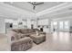 Expansive living room with open layout to kitchen, white cabinetry, stainless steel appliances, and modern decor at 12539 Wetmore Ct, Odessa, FL 33556