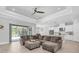 Open concept living room with a large sectional sofa and seamless access to the screened-in pool area at 12539 Wetmore Ct, Odessa, FL 33556