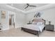 Light primary bedroom with a ceiling fan and a large window to view outside. Features wood-look floors at 12539 Wetmore Ct, Odessa, FL 33556