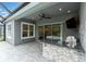 Covered outdoor kitchen with stone accents, stainless steel grill, and a view of the backyard at 12539 Wetmore Ct, Odessa, FL 33556