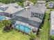 Aerial view of the backyard featuring a screened-in pool, patio furniture, and well-maintained lawn at 12539 Wetmore Ct, Odessa, FL 33556