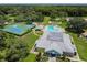 Aerial view showcasing the community amenities, including tennis and pool, nestled in a mature landscape at 13039 Topflite Ct, Hudson, FL 34669