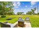 Backyard patio featuring wicker furniture and a gas fire pit, perfect for outdoor gatherings at 13039 Topflite Ct, Hudson, FL 34669