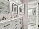 Bathroom with double sink vanity, modern fixtures, framed mirrors, and a tiled shower at 13039 Topflite Ct, Hudson, FL 34669