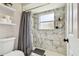 Bathroom with a gray shower curtain, tiled shower, and modern fixtures at 13039 Topflite Ct, Hudson, FL 34669