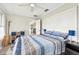 Bright bedroom with a ceiling fan, a comfortable bed, and a printer on a stylish shelving unit at 13039 Topflite Ct, Hudson, FL 34669