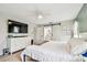 Bedroom featuring a ceiling fan, TV, adjacent bathroom and sliding barn door at 13039 Topflite Ct, Hudson, FL 34669