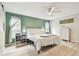 Bedroom featuring a white bed, light-colored floors, ceiling fan, and green accent wall at 13039 Topflite Ct, Hudson, FL 34669