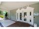 Clubhouse entrance featuring glass doors, an awning, tile flooring, and signage with community information at 13039 Topflite Ct, Hudson, FL 34669