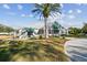 Attractive clubhouse with a palm tree in the manicured yard and accessible parking on a sunny day at 13039 Topflite Ct, Hudson, FL 34669