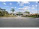 Exterior view of the clubhouse with a palm tree and accessible parking on a sunny day at 13039 Topflite Ct, Hudson, FL 34669
