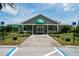 Charming clubhouse with green awnings, attractive landscaping, accessible ramp, and designated accessible parking at 13039 Topflite Ct, Hudson, FL 34669