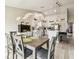 Bright dining room with modern lighting fixture and a view of the updated kitchen with stainless steel appliances at 13039 Topflite Ct, Hudson, FL 34669
