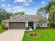 Charming single-story home with a well-manicured lawn, mature landscaping, and an attached two-car garage at 13039 Topflite Ct, Hudson, FL 34669