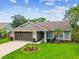 Charming single-story home with a well-manicured lawn, mature landscaping, and an attached two-car garage at 13039 Topflite Ct, Hudson, FL 34669