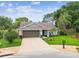 Lovely single-Gathering home boasts a green lawn, mature landscaping, and an attached garage, radiating curb appeal at 13039 Topflite Ct, Hudson, FL 34669
