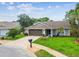 Well-maintained single-story home featuring a lush lawn, mature trees, and a convenient two-car garage at 13039 Topflite Ct, Hudson, FL 34669