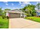 Charming single-story home with well-manicured lawn, mature trees and attached two car garage at 13039 Topflite Ct, Hudson, FL 34669