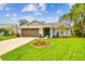 Charming single-story home with well-manicured lawn, mature trees and attached two car garage at 13039 Topflite Ct, Hudson, FL 34669