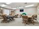 Spacious game room featuring card tables, a poker table, ample seating, and a ceiling fan for comfortable entertainment at 13039 Topflite Ct, Hudson, FL 34669