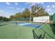 Bright pickleball court surrounded by green trees featuring blue and green court surfaces and a net at 13039 Topflite Ct, Hudson, FL 34669