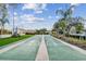 Daytime view of the shuffleboard court, picnic benches, and manicured lawn at 13039 Topflite Ct, Hudson, FL 34669
