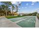 Daytime view of the shuffleboard court, picnic benches, and manicured lawn at 13039 Topflite Ct, Hudson, FL 34669
