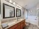 Bathroom featuring double sinks with granite countertops, framed mirrors, a soaking tub and a separate glass shower at 13850 Royston Bnd, Hudson, FL 34669