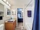 Bathroom with single sink, vanity with granite countertop and a tub-shower combination, plus a view to bedroom at 13850 Royston Bnd, Hudson, FL 34669