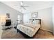 Cozy bedroom with queen bed, floral bedding, ceiling fan, desk, and a treadmill for a functional workout space at 13850 Royston Bnd, Hudson, FL 34669