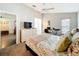 Bright bedroom with a queen bed, floral bedding, ceiling fan, and a workspace with a desk and treadmill at 13850 Royston Bnd, Hudson, FL 34669
