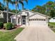 Well-maintained two-story home with a manicured lawn, mature trees, and a spacious driveway at 13850 Royston Bnd, Hudson, FL 34669
