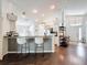 Open kitchen featuring a breakfast bar with sleek white bar stools and modern lighting fixtures at 13850 Royston Bnd, Hudson, FL 34669