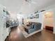 Open-concept living room with dark wood floors, stylish sectional sofa, and seamless transition to the kitchen at 13850 Royston Bnd, Hudson, FL 34669