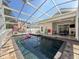 Relaxing screened-in pool with a lounge area and an in-pool float providing a perfect backyard oasis at 13850 Royston Bnd, Hudson, FL 34669