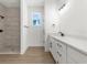 Contemporary bathroom features tiled shower, white vanity with black hardware, and plenty of light at 14042 Amero Ln, Spring Hill, FL 34609