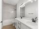 Modern bathroom with double vanity, sleek white countertops, a large mirror, and a beautifully tiled shower at 14042 Amero Ln, Spring Hill, FL 34609